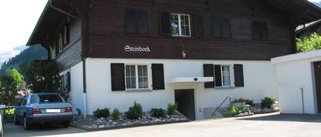 A two-story building with a wooden facade and the name 'Esteinbock' on the front.