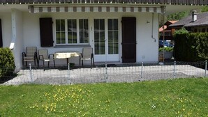 Un bâtiment doté d’un patio couvert, d’une table et de deux chaises.