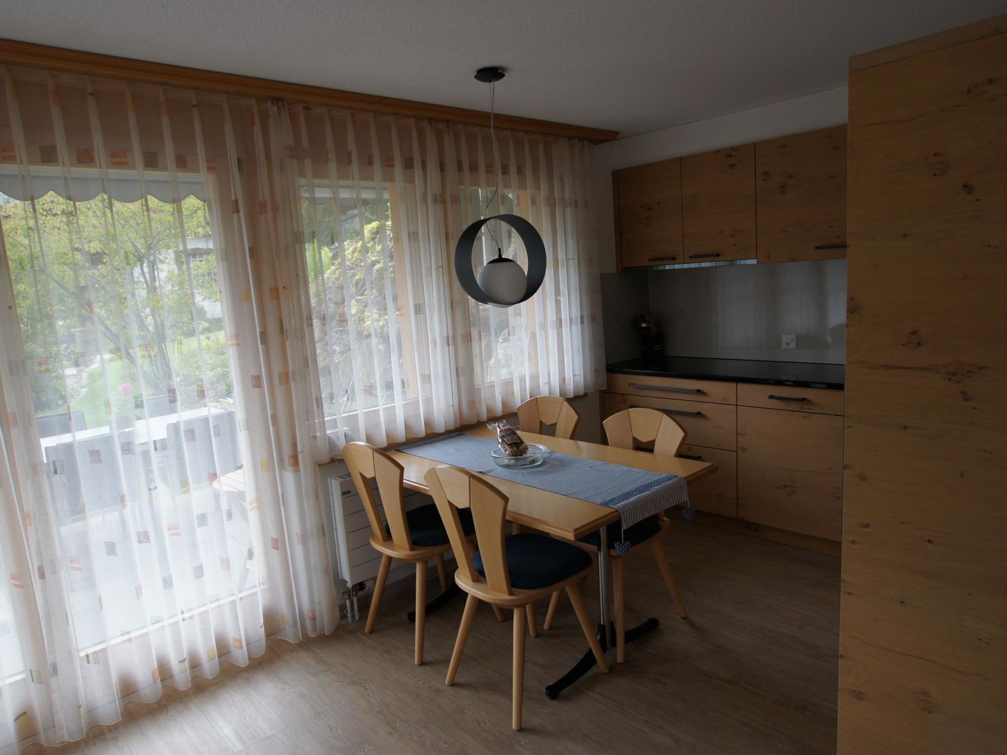 Un coin repas avec une table, des chaises et une horloge au mur.
