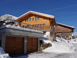Eine Holzhütte mit Balkon, Garage und Bergblick.