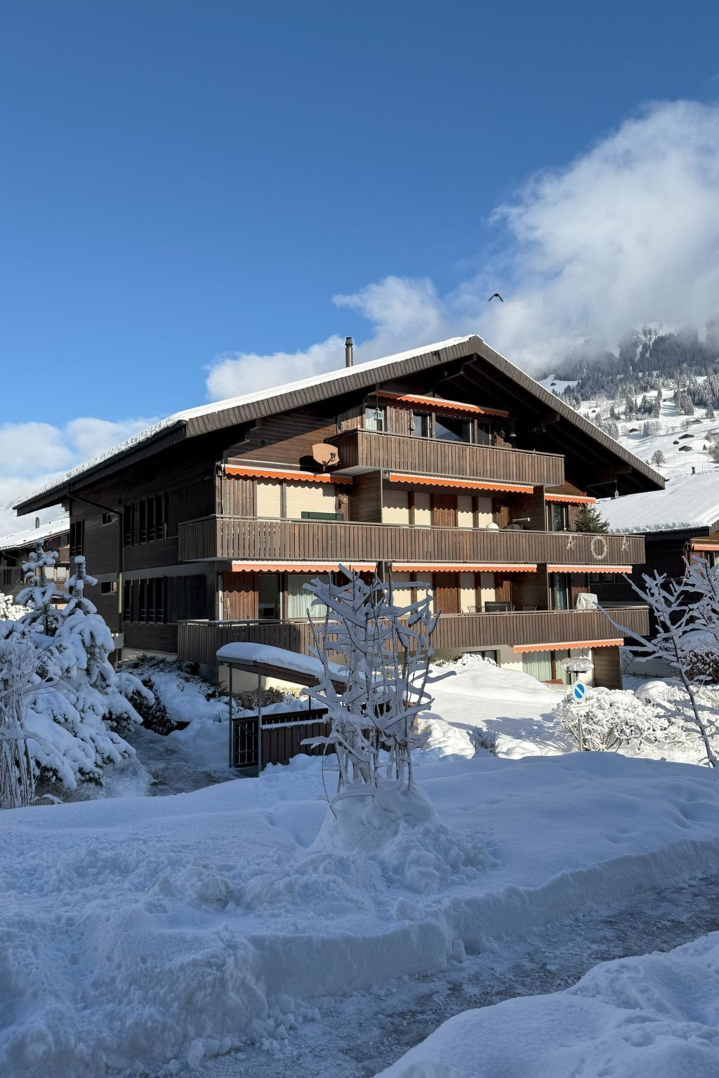 A multi-story chalet with a sloped roof, wooden exterior, and balconies.