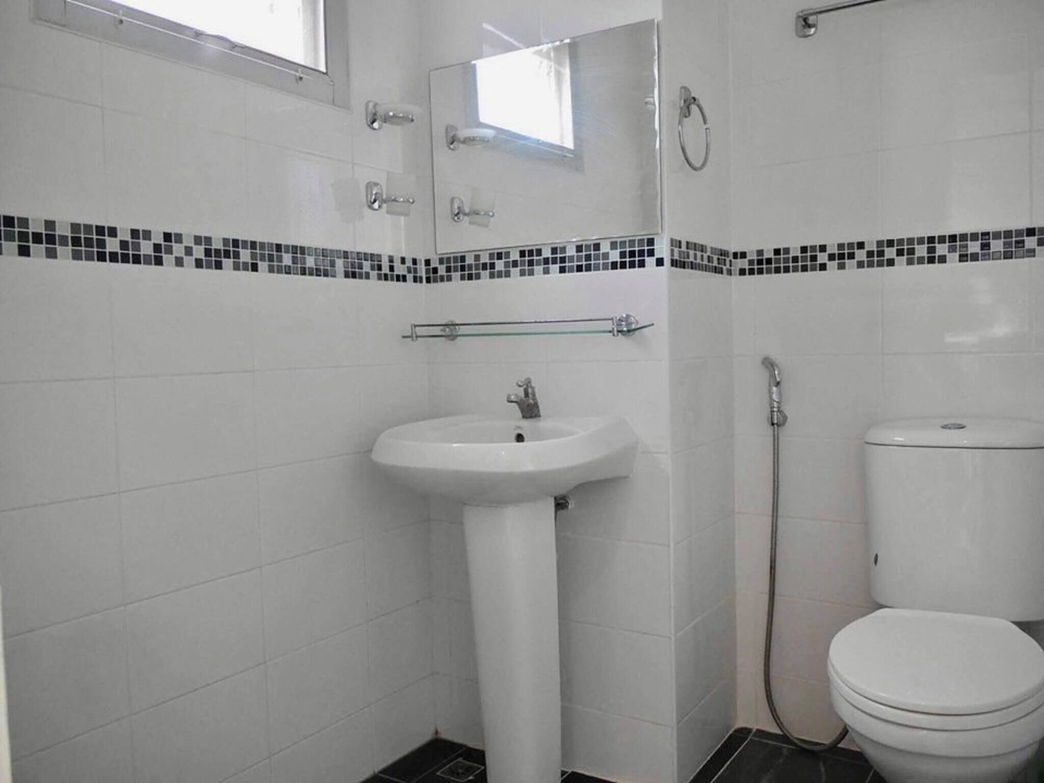 A bathroom with a white sink, a toilet, and a shower.