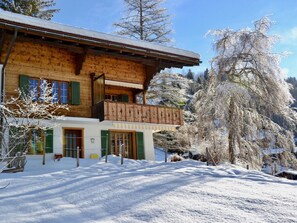 A wooden chalet with a balcony, surrounded by snow-covered trees. - Am Brüggli # 1 Appartement/Fewo, Dusche, WC, Erdgeschoß/Parterre 2-Bett-Wohnung by Interhome (Lenk)
