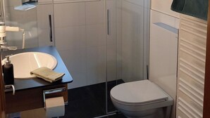 A modern bathroom with a glass shower enclosure, a white toilet, and a sink with a towel. - Am Brüggli # 1 Appartement/Fewo, Dusche, WC, Erdgeschoß/Parterre 2-Bett-Wohnung by Interhome (Lenk)