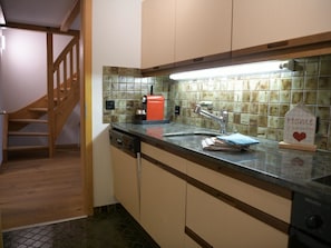 A kitchen with a coffee maker, a sink, and a sign that says 'Home is where the heart is.' - Chalet Sunnebort Appartement/Fewo, Bad, WC, 2 Schlafräume 5-Bettwohnung by Interhome (Lenk)
