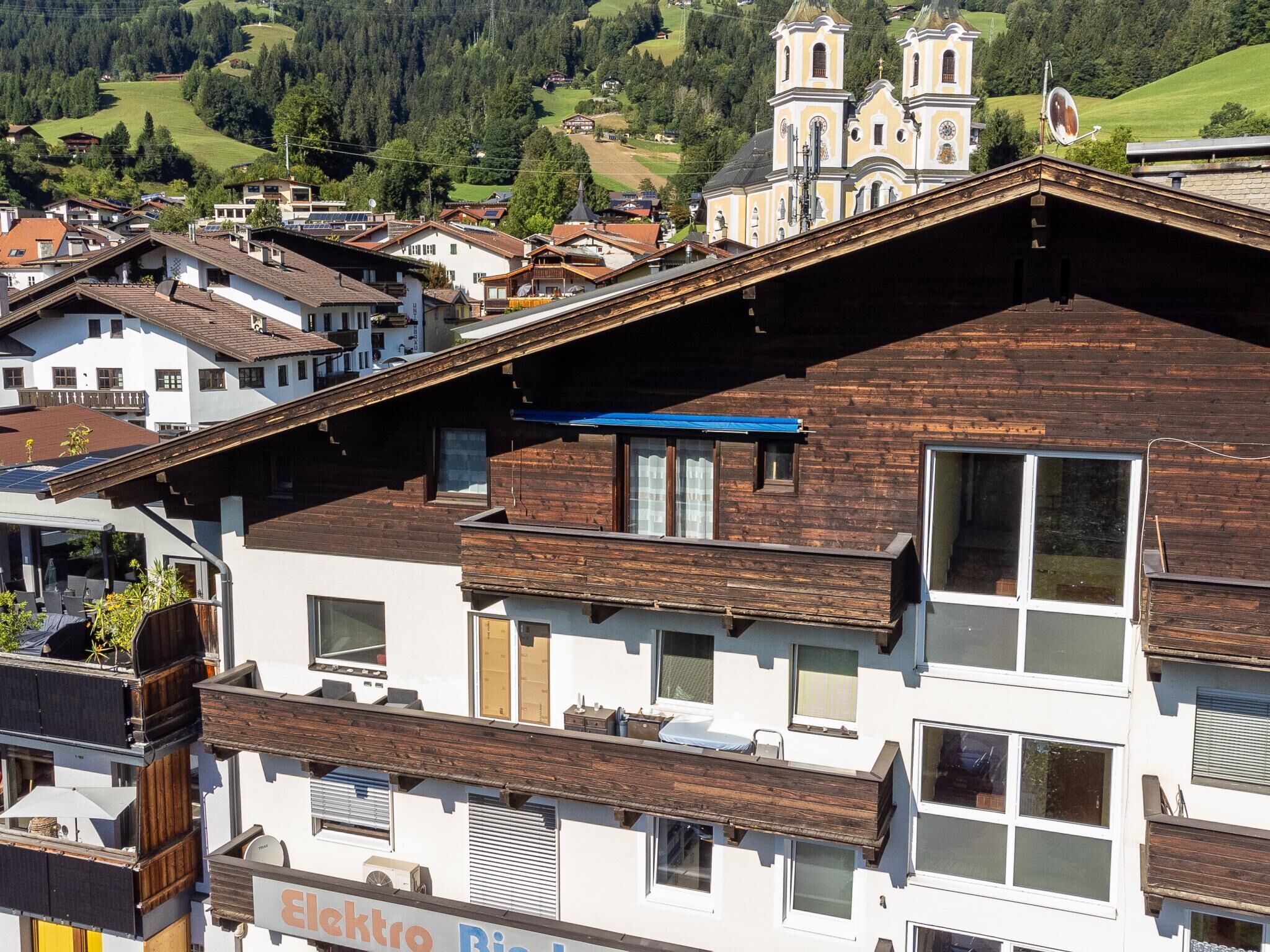 Un immeuble d’habitation doté d’un toit en pente, de nombreuses fenêtres et d’une antenne parabolique bien visible.