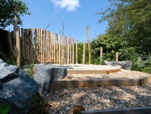 A garden with a wooden fence, large rocks, and a gravel path. - Vacation home near the North Sea beach. (Kamperland)