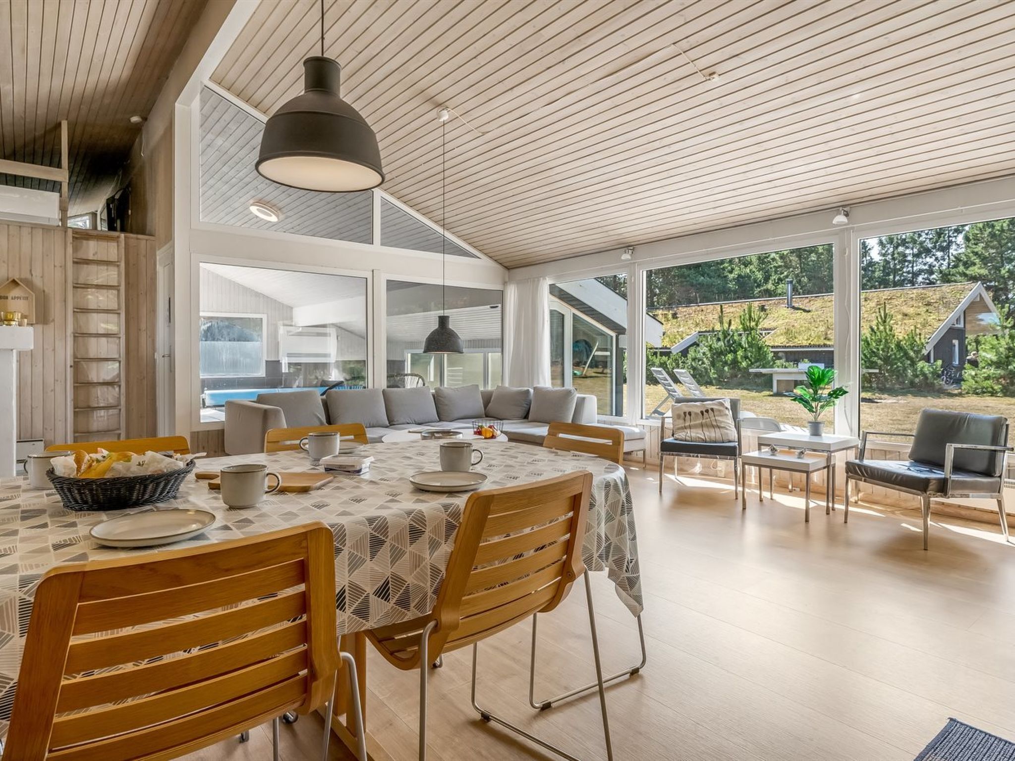 A modern dining area with a table set for two, a large window, and a view of the outdoors.