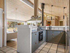 A modern kitchen with a built-in oven, a sink, and a dining area with a view of the outdoors. - "Elja" - 1km from the sea by Interhome (Saltum)