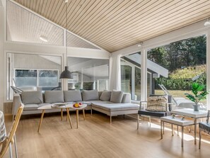 Ein modernes Wohnzimmer mit einer großen Eckcouch, einem Couchtisch und einem Essbereich mit Tisch und Stühlen.