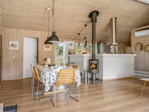 Eine moderne Küche mit einer zentralen Kochinsel, Holzböden und einem Kaminofen.