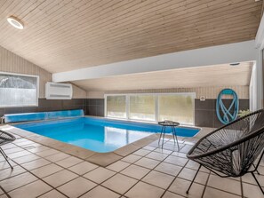 An indoor swimming pool with a tiled floor, a ceiling with wooden slats, and a window with a view. - "Elja" - 1km from the sea by Interhome (Saltum)