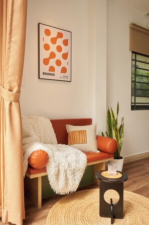 A cozy living room with a sofa, a coffee table, and a potted plant. - Studio with chill balcony: D3 Apt By D Haus (Thành phố Hồ Chí Minh)
