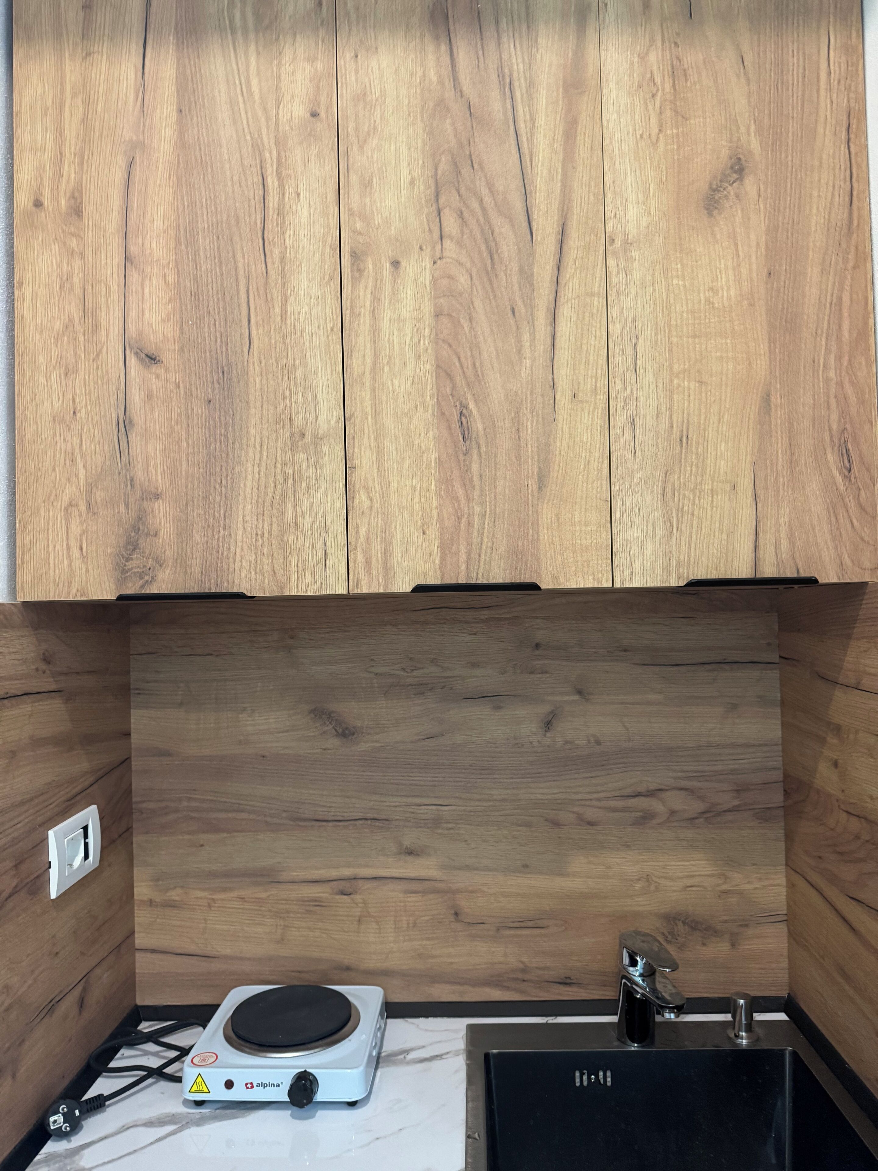 A kitchen with wooden cabinets, a built-in stove, and a sink.