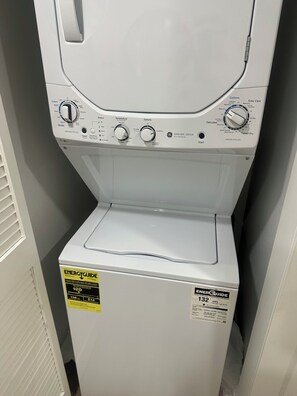 A front view of a front-loading washing machine with control knobs and a label indicating energy consumption. - Fabulous Cozy Corporate Pvt luxury 1/1bth condo across UNLV,Strip!! (Las Vegas)