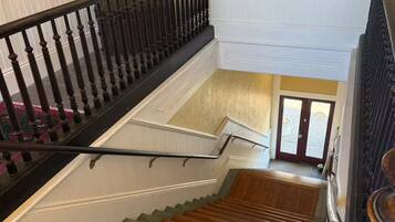 A multi-level staircase with a handrail, carpeted steps, and a view of the lower level.