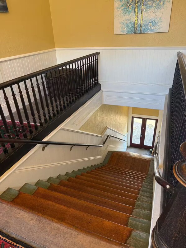 A multi-level staircase with a handrail, carpeted steps, and a view of the lower level.