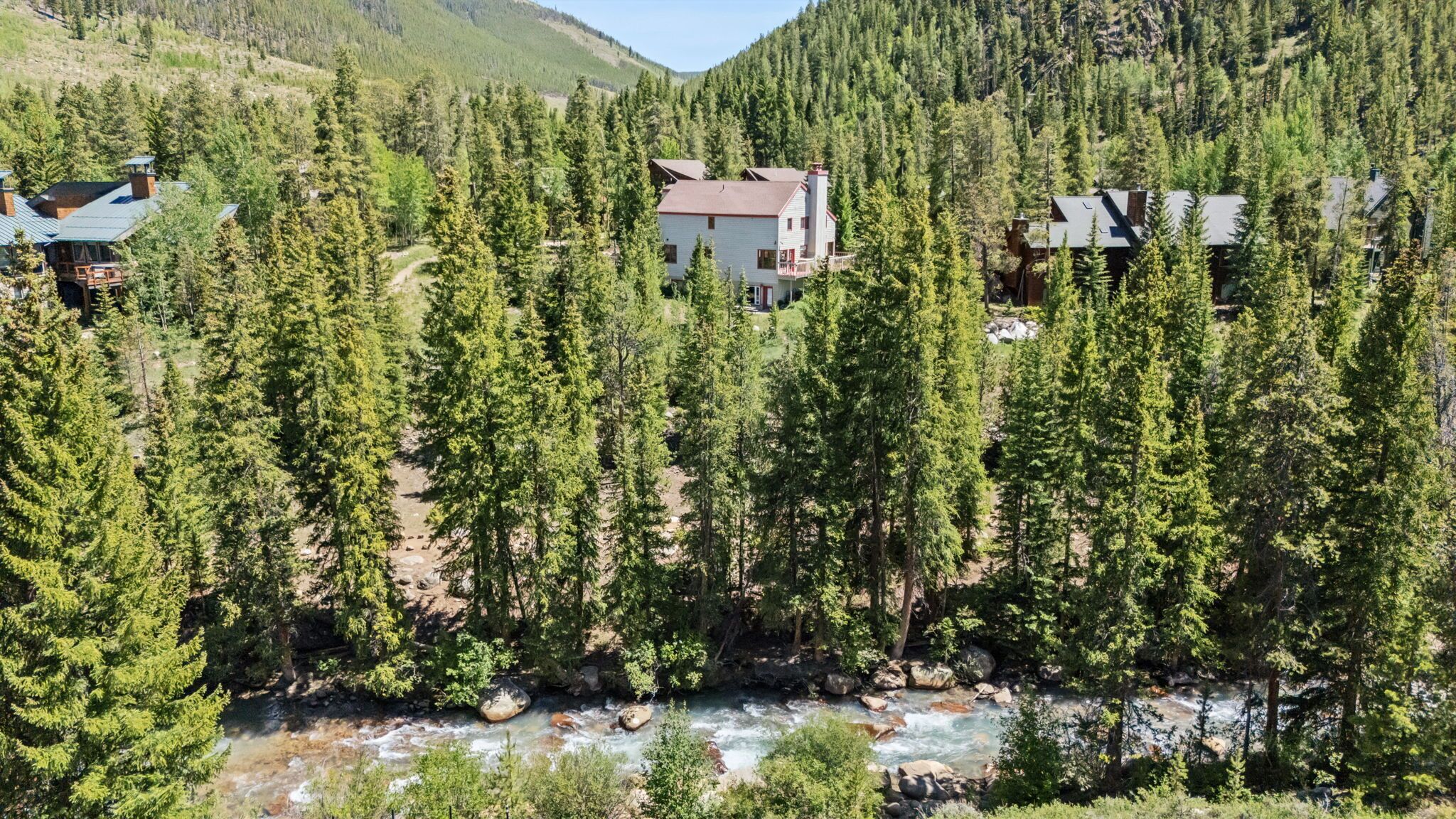 Een lodge omringd door dicht bos en een meanderende rivier.