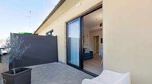 A modern outdoor patio with a sliding glass door leading to a living area. - Palette Bergonzoli Place (Milano)