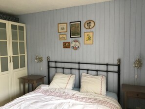 Ein Schlafzimmer mit Bett, Nachttischen und einem Kleiderschrank.