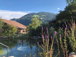 A serene lakeside view with a mountain backdrop, a wooden building with a red roof, and lush greenery. - Strubeli Appartement/Fewo, Dusche oder Bad, WC, 2 Schlafräume 4-Bett-Wohnung by Interhome (St Stephan)