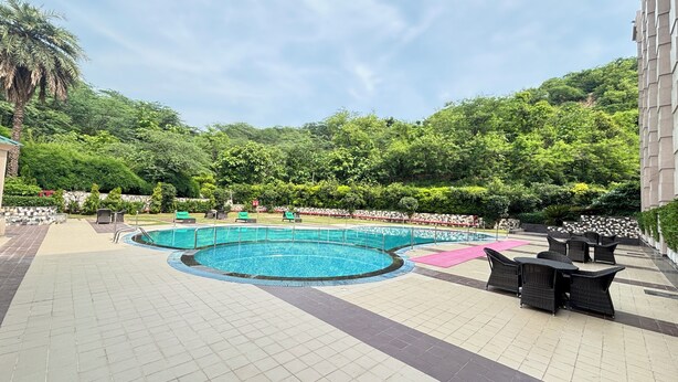 A swimming pool with lounge chairs and a tiled deck.