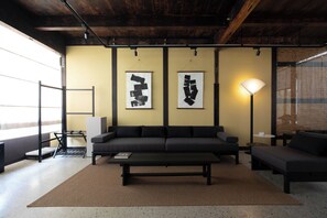 A modern living room with a sofa, a coffee table, and two wall-mounted artworks.