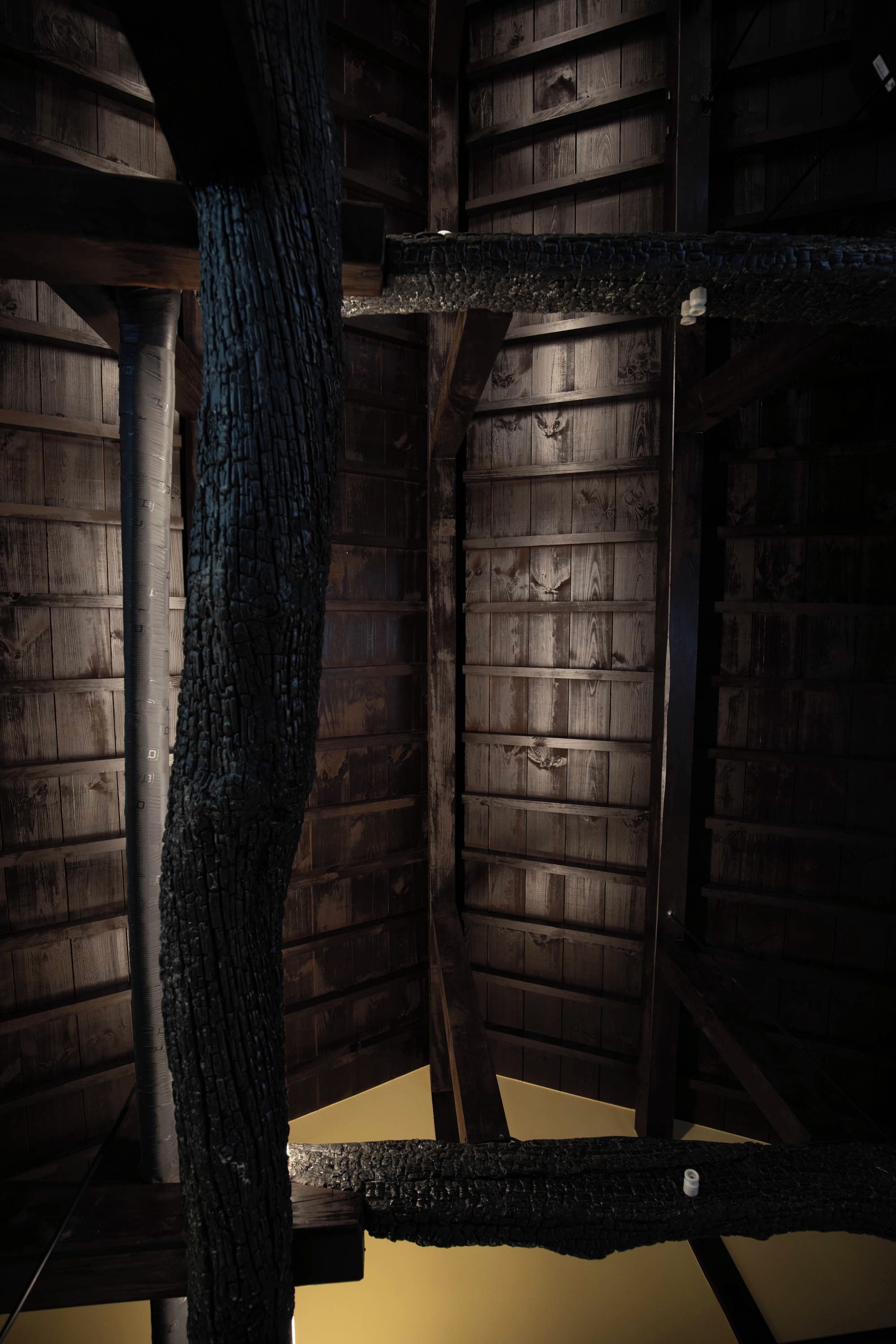 A room with wooden walls and a central support column.
