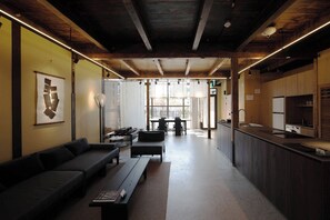 A modern interior with a sofa, a dining table, and a kitchen area.
