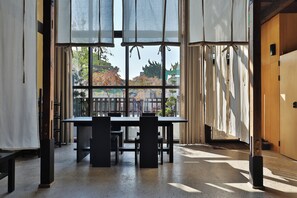 Una habitación con un ventanal amplio, una mesa y sillas.