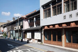 A street with traditional buildings, including a restaurant with a sign in a foreign script.