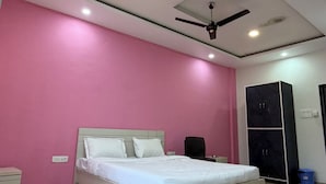 Un dormitorio con cama, ventilador de techo, iluminación empotrada y armario.