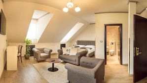 Une chambre de style loft moderne, avec un plafond en pente, un lit, un canapé et une table à manger.