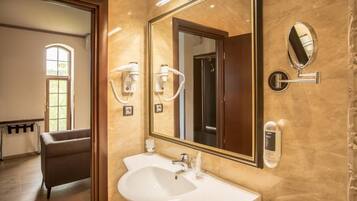 A bathroom with a large mirror, a sink, and a hairdryer.