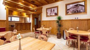 Un restaurant avec des meubles en bois, une plante en pot et des tableaux encadrés accrochés au mur.