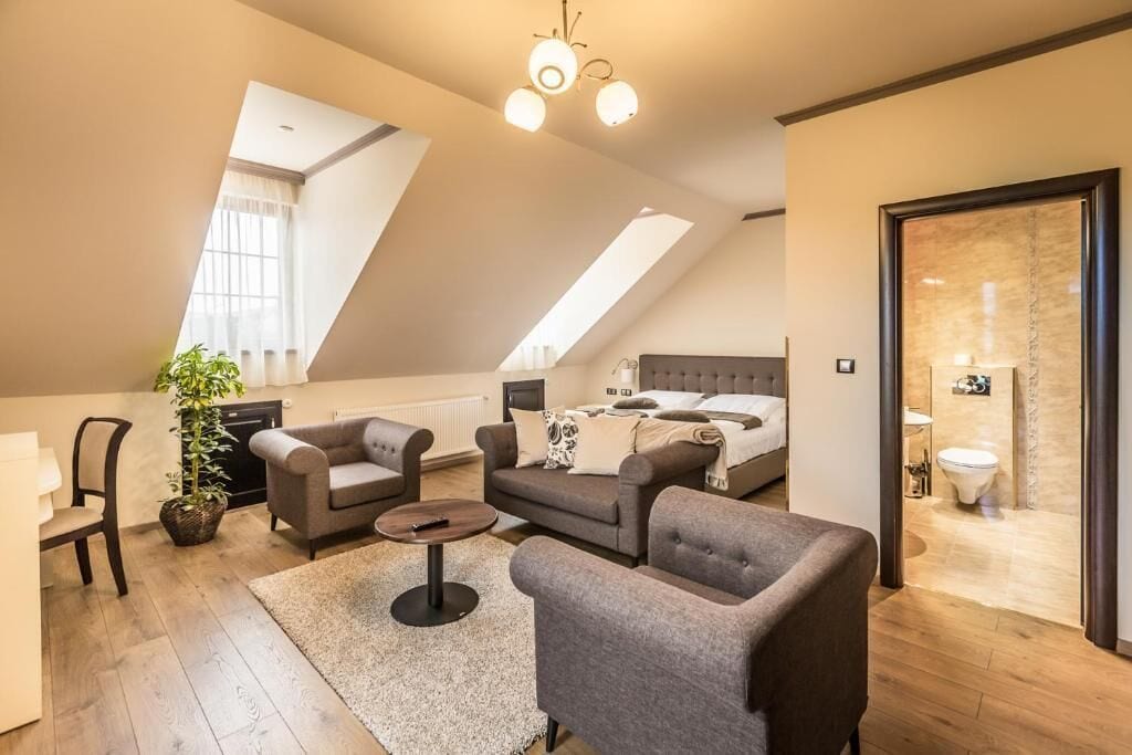 Une chambre moderne de style loft, dotée d’un plafond en pente, d’un lit, d’un canapé et d’un coin repas.