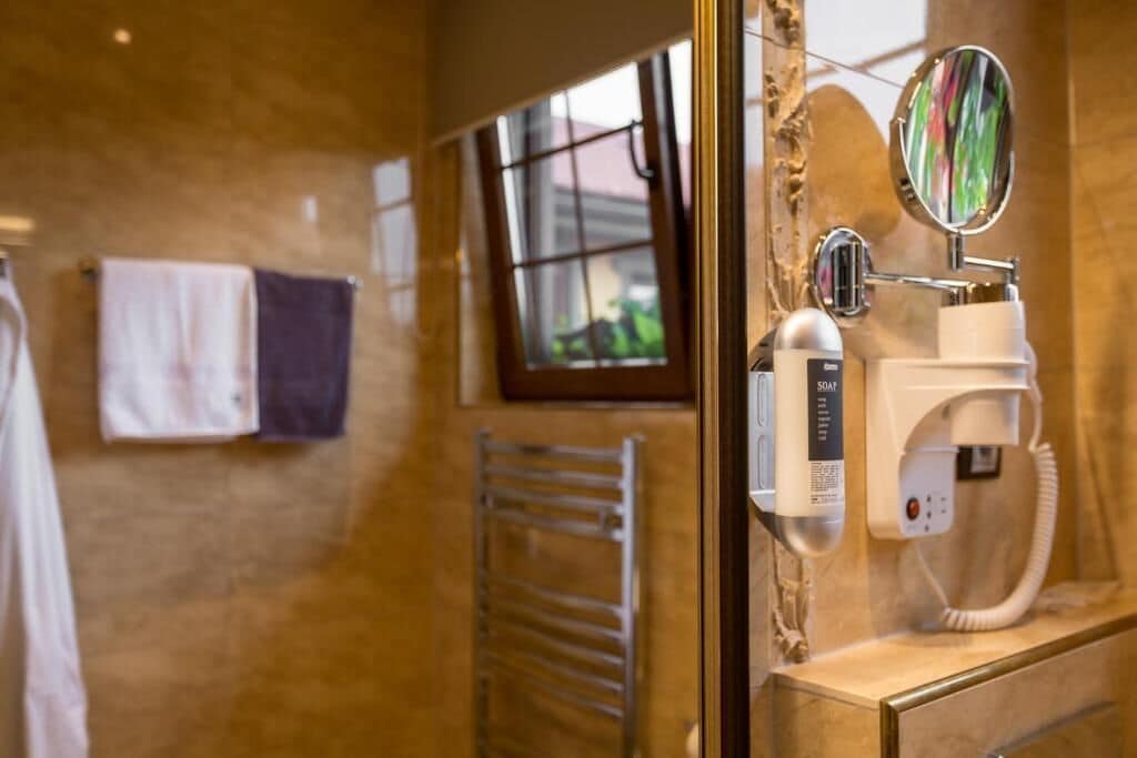 Un baño con un secador de manos, un perchero para toallas y una ventana con vistas.