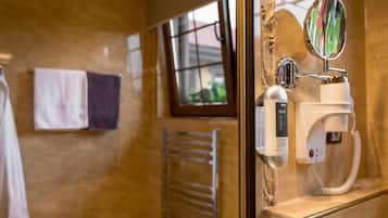 Un baño con un secador de manos, un perchero para toallas y una ventana con vistas.
