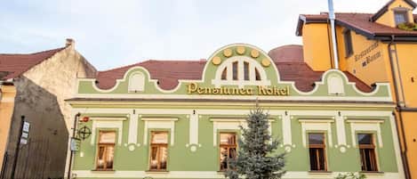 A building with a green facade and a sign that reads 'Penstumer Hof.'