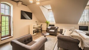 Une chambre spacieuse aménagée en loft, avec une grande fenêtre, un lit, un bureau et une chaise.