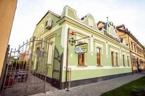 Un edificio verde con un cartel que indica 'Hotel Petrovka' y una entrada visible.