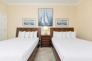 A hotel room with two beds, a nightstand, and a painting above the beds. - Phoenix Orange Beach 1202 (Orange Beach)