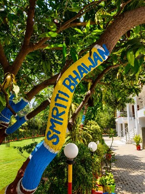A tree with a sign reading 'SYRIYA BHALYAN' wrapped around it. - Smiriti Bhawan (Varanasi)