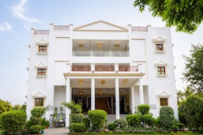 A two-story building with a symmetrical facade, a central entrance with columns, and a balcony on the upper floor. - Smiriti Bhawan (Varanasi)