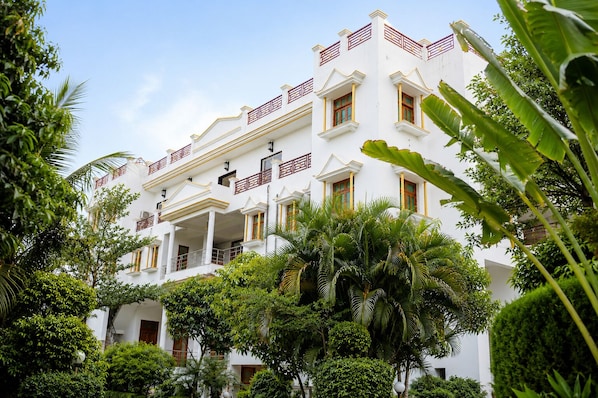 A multi-story building with balconies and a lush garden. - Smiriti Bhawan (Varanasi)