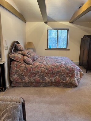 A bedroom with a bed, a window, a lamp, and a wardrobe. - Beautiful 1-bedroom cottage in charming Evergreen perfect for relaxing getaway (Evergreen)