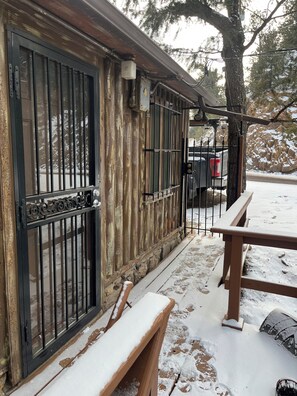 A wooden exterior with a metal gate, a bench, and a parked vehicle. - Beautiful 1-bedroom cottage in charming Evergreen perfect for relaxing getaway (Evergreen)