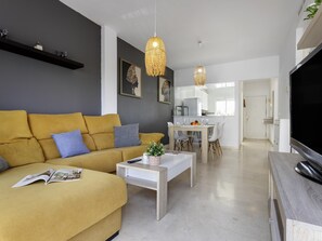 A modern living room with a sofa, coffee table, and a TV. - Sunstay Flat Torrequebrada (Benalmádena)