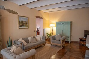 A living room with a sofa, armchairs, a lamp, a cabinet, and a painting on the wall. - Private Tuscan Villa with Pool & Spa (Croce)