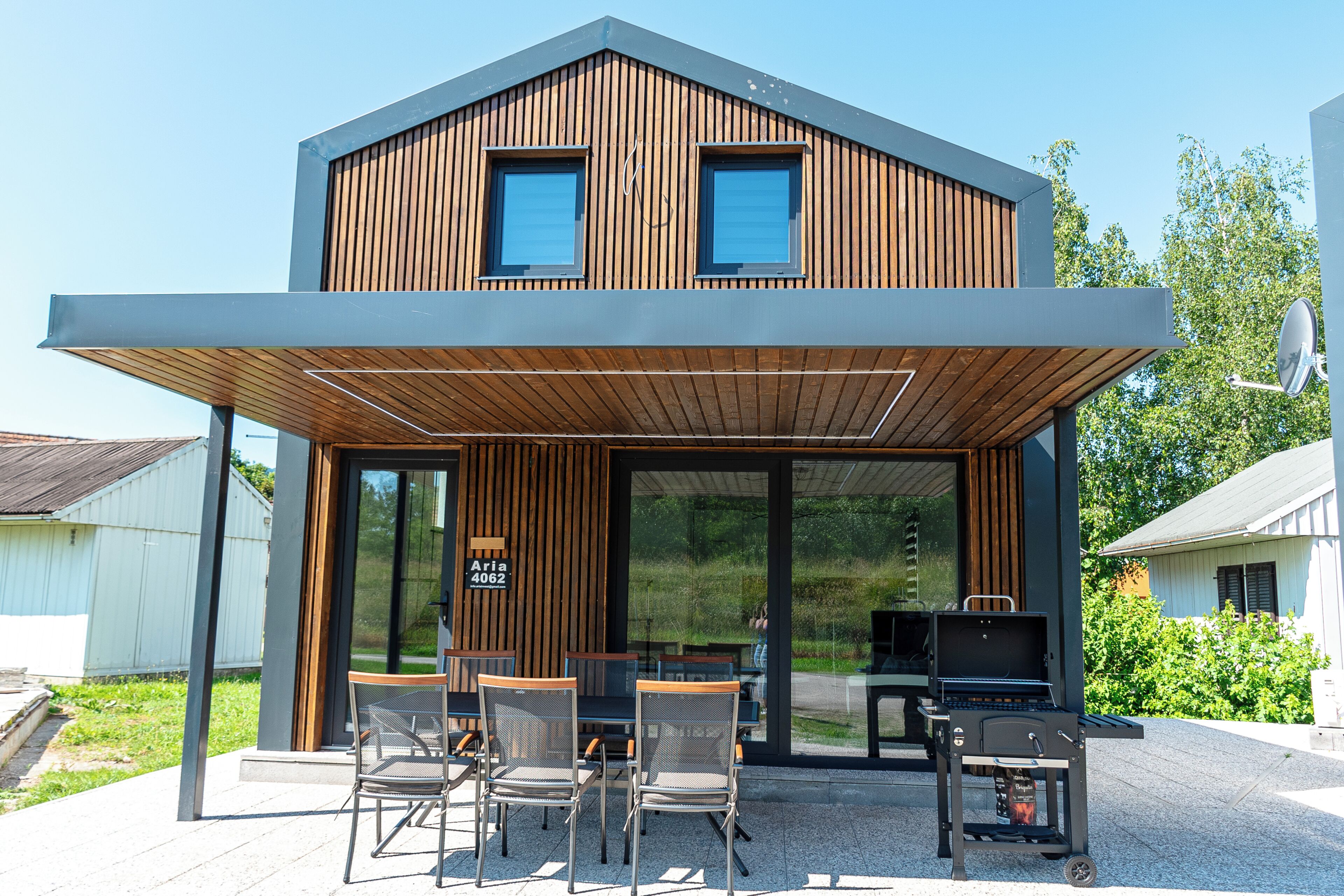 A modern two-story building with a covered patio area.